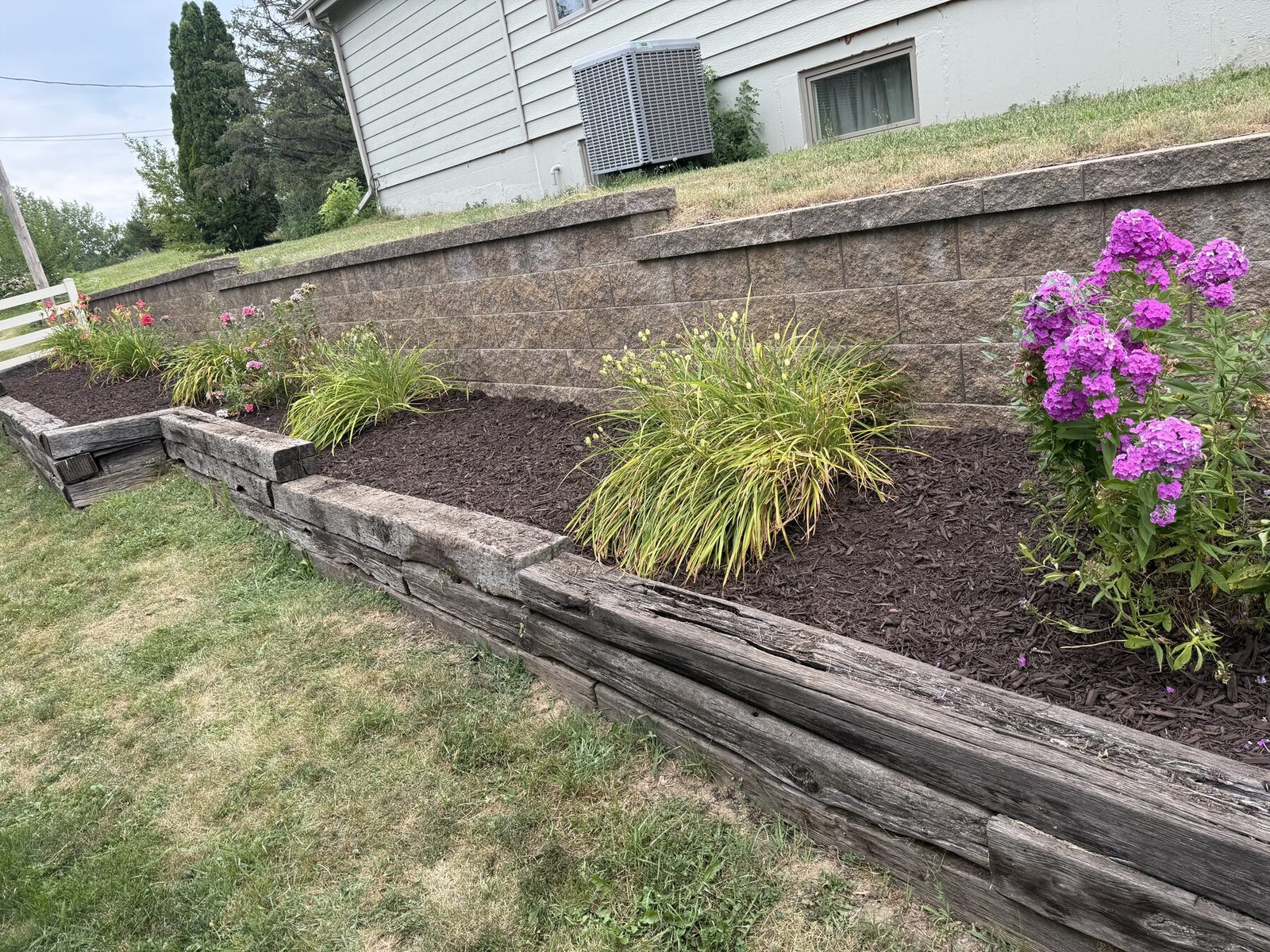 Raised garden bed with retaining wall and flowers